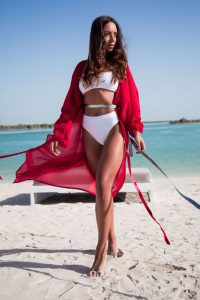 Woman in red dress standing on beach